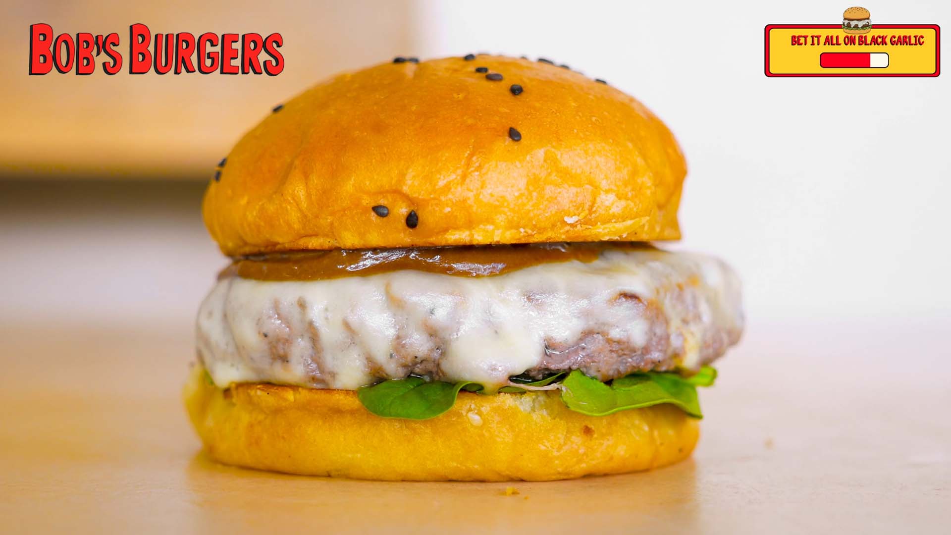 Glossy brown garlic sauce over melted cheese and spinach in a sesame brioche bun