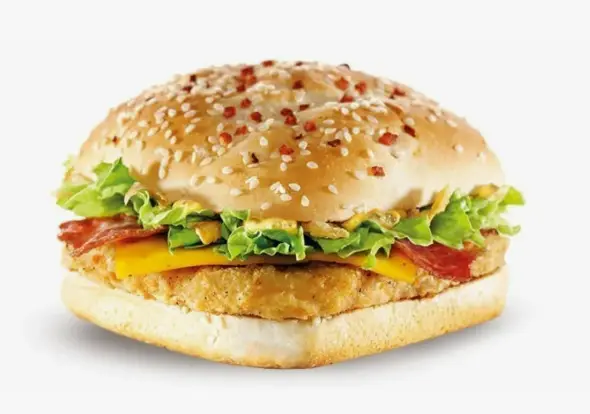Close-up of a breaded chicken fillet with melted cheddar in a sesame seed bun