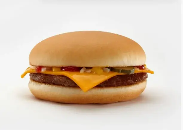 Close-up of a beef patty with melted American cheese in a soft burger bun