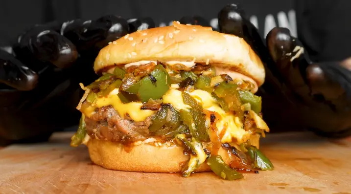 Close-up of a beef patty with melted American cheese in a brioche bun