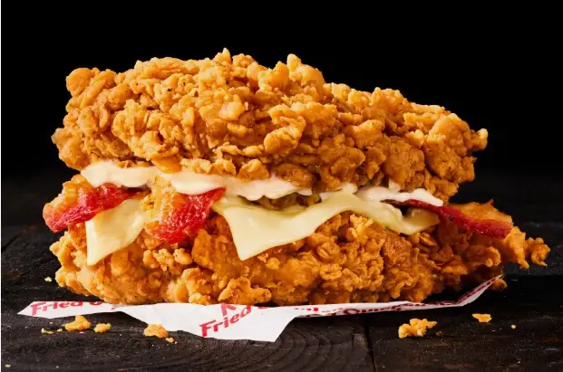 Close-up of a breaded chicken fillet with Monterey Jack and bacon served open