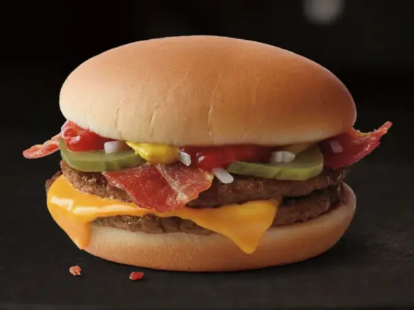 Close-up of a beef patty with melted American cheese in a soft burger bun