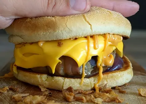 Close-up of a beef patty with melted cheddar in a brioche bun