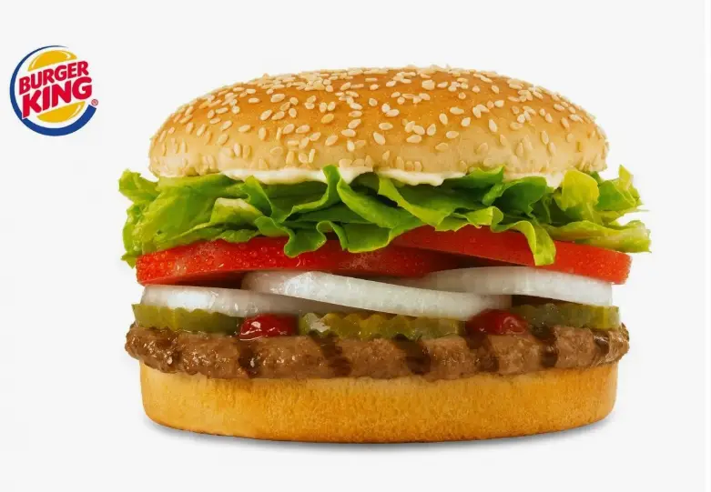 Close-up of a smashed beef patty with melted American cheese in a sesame seed bun