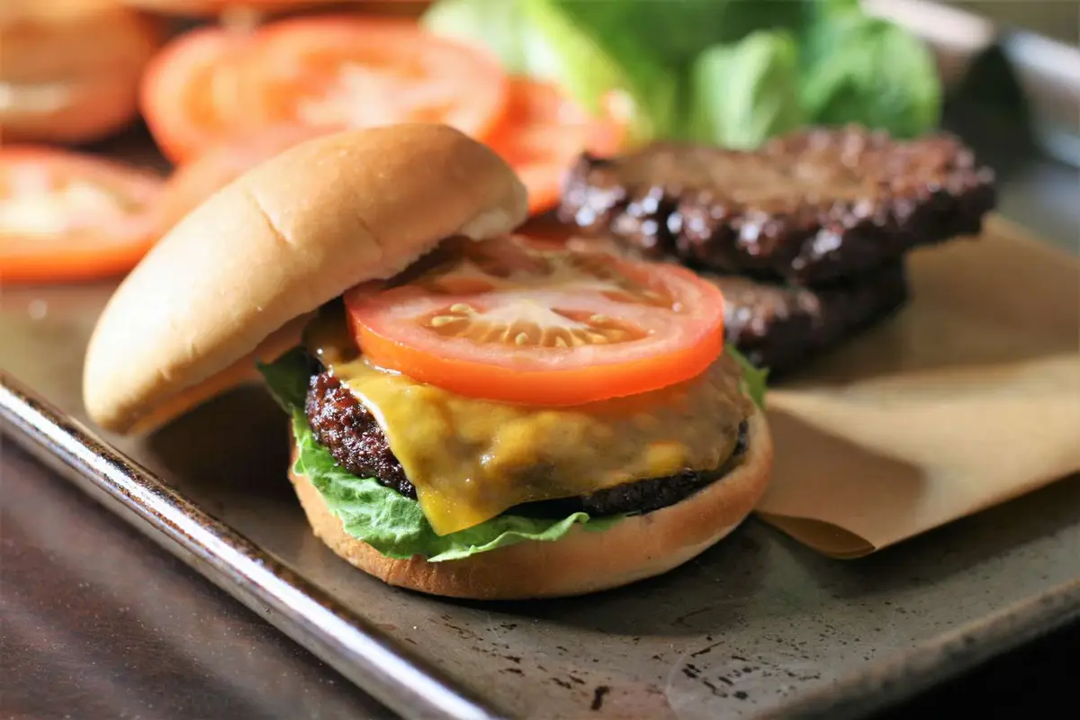 Close-up of a beef patty served open, shot close on a plain background