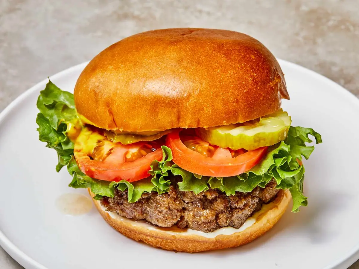 Close-up of a beef patty with a fried egg served open
