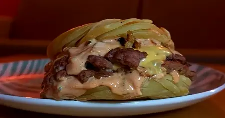 Close-up of a smashed beef patty with melted American cheese in paratha flatbread