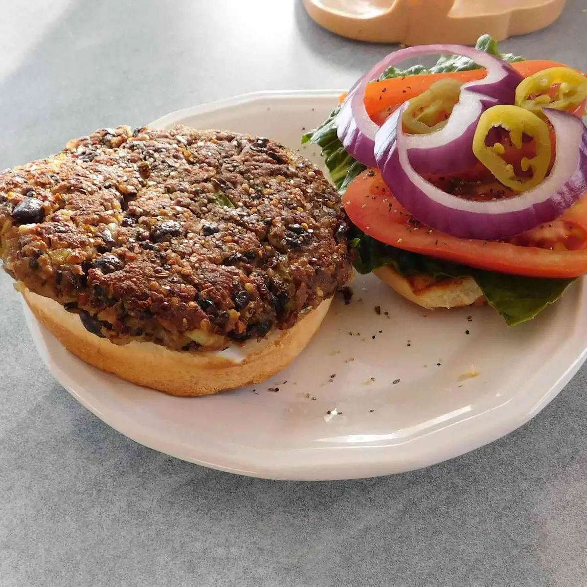 Close-up of a black bean patty with peppers and a fried egg