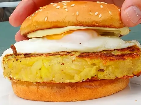 Close-up of a burger patty with a fried egg in a soft burger bun
