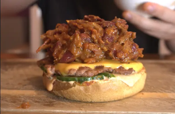 Close-up of a smashed beef patty with melted American cheese in a brioche bun
