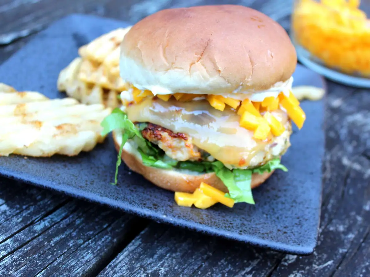 Close-up of a chicken patty with gouda in a soft burger bun