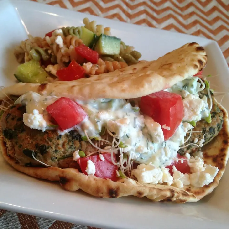 Close-up of a turkey patty with crumbled feta, spinach and a fried egg served open